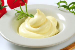 portion of homemade mayonnaise, decorated with herb